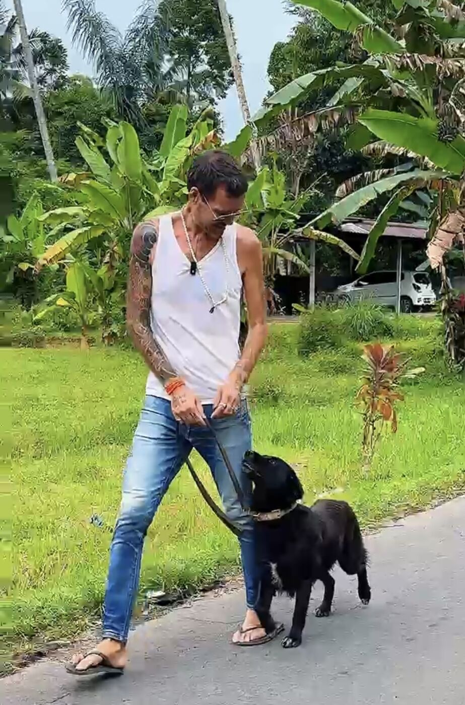 Stephan Mairesse walking a black dog on leash
