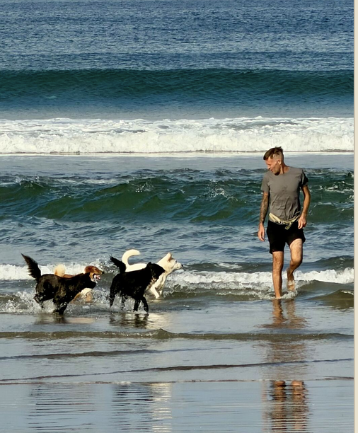 Stephan Mairesse running on the beach with two dogs